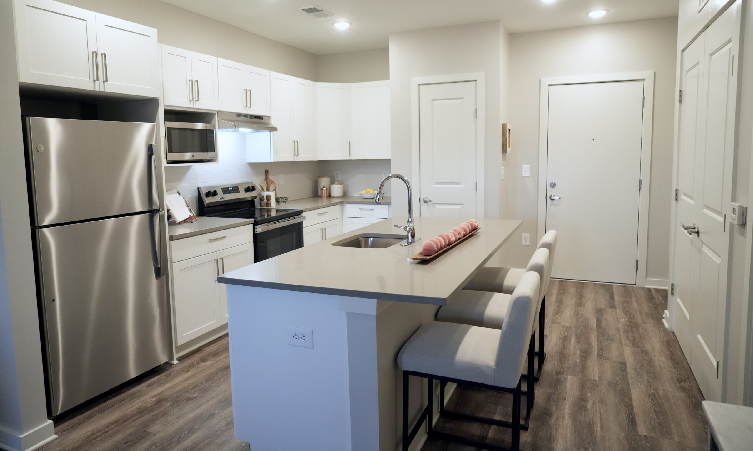 Apartment kitchen with stainless steel appliances and quartz island