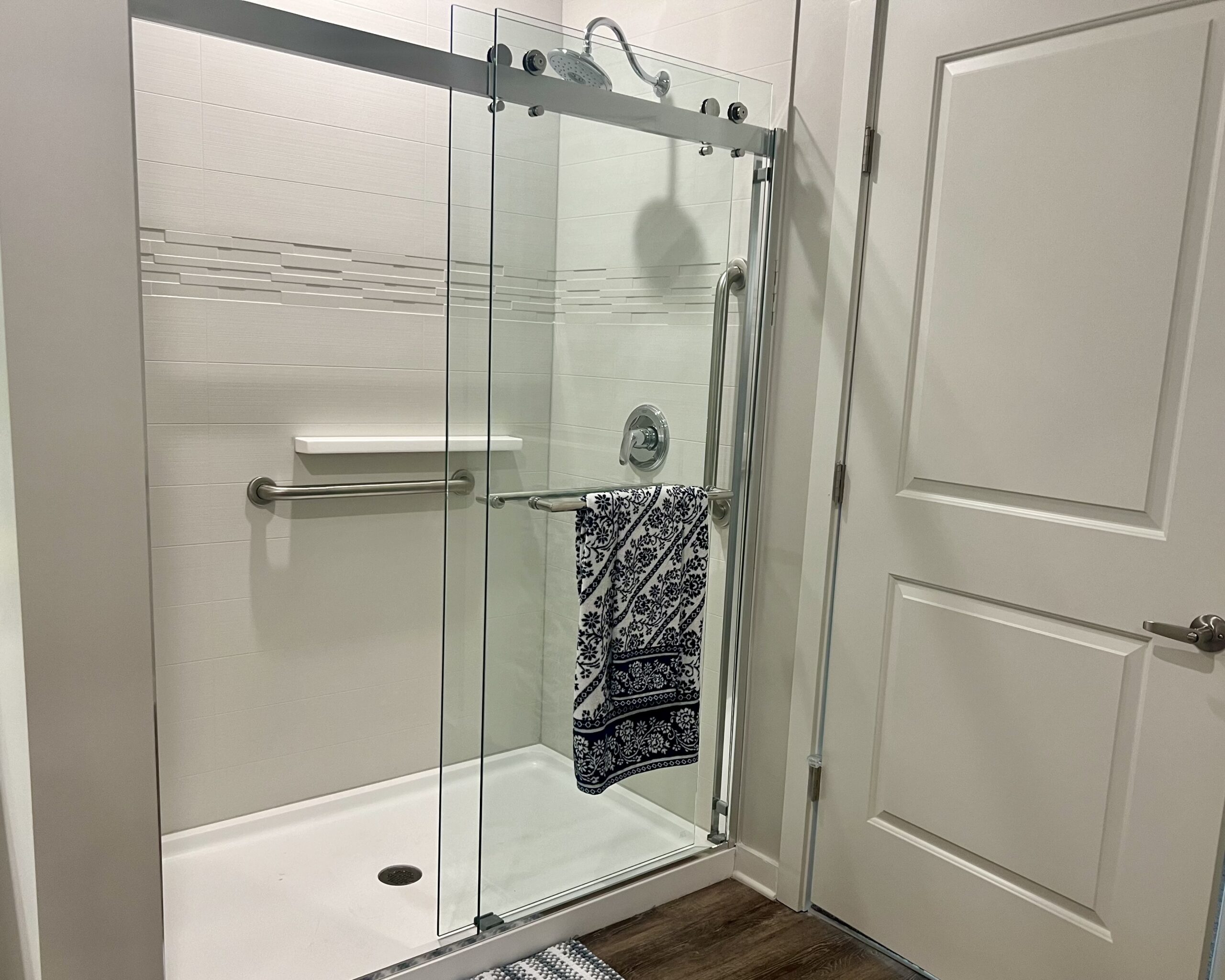 Glass-enclosed stand-up shower with grab bars