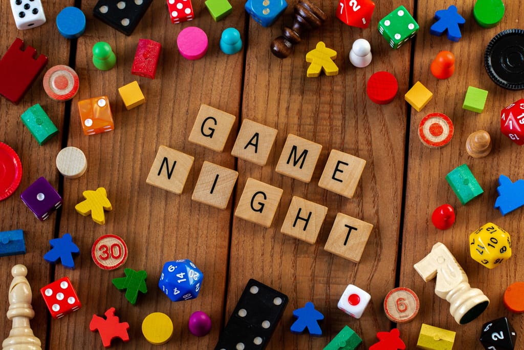 Board game pieces and dice surrounding the words Game Night