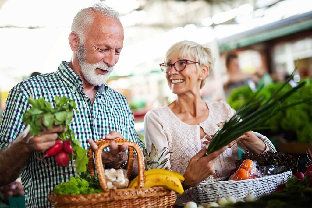 Older couple choosing fresh produce at a market