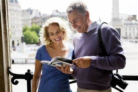 Older couple reading a travel guide on a balcony