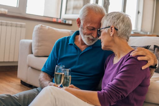 Older couple sitting together with glasses of sparkling wine