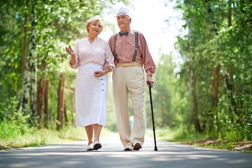 Older couple walking together on a wooded path
