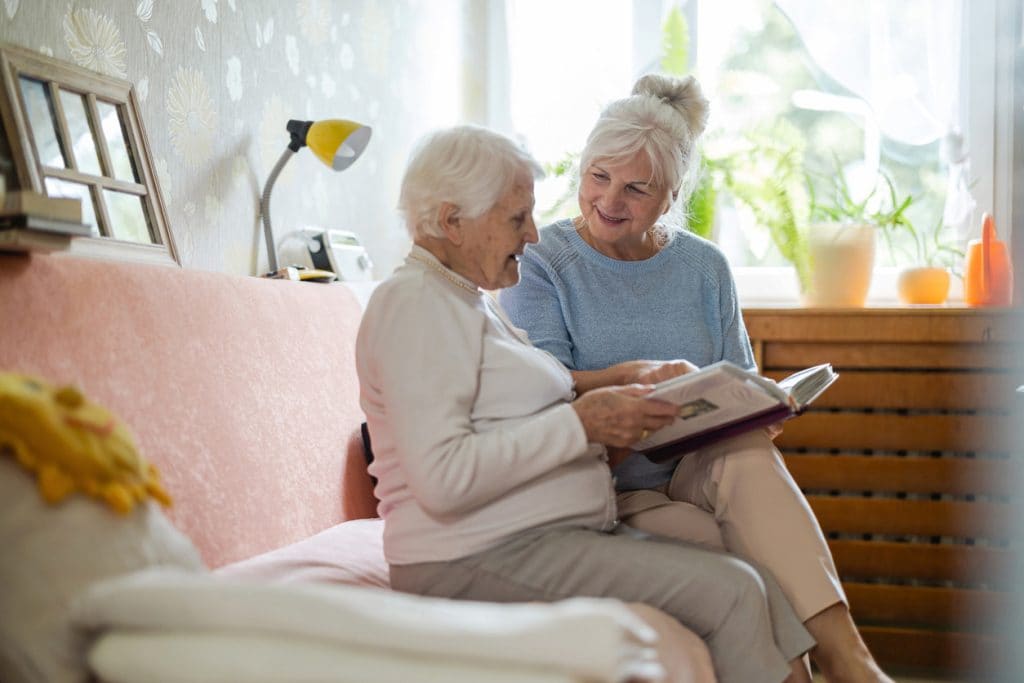 Two older women looking through a photo album together